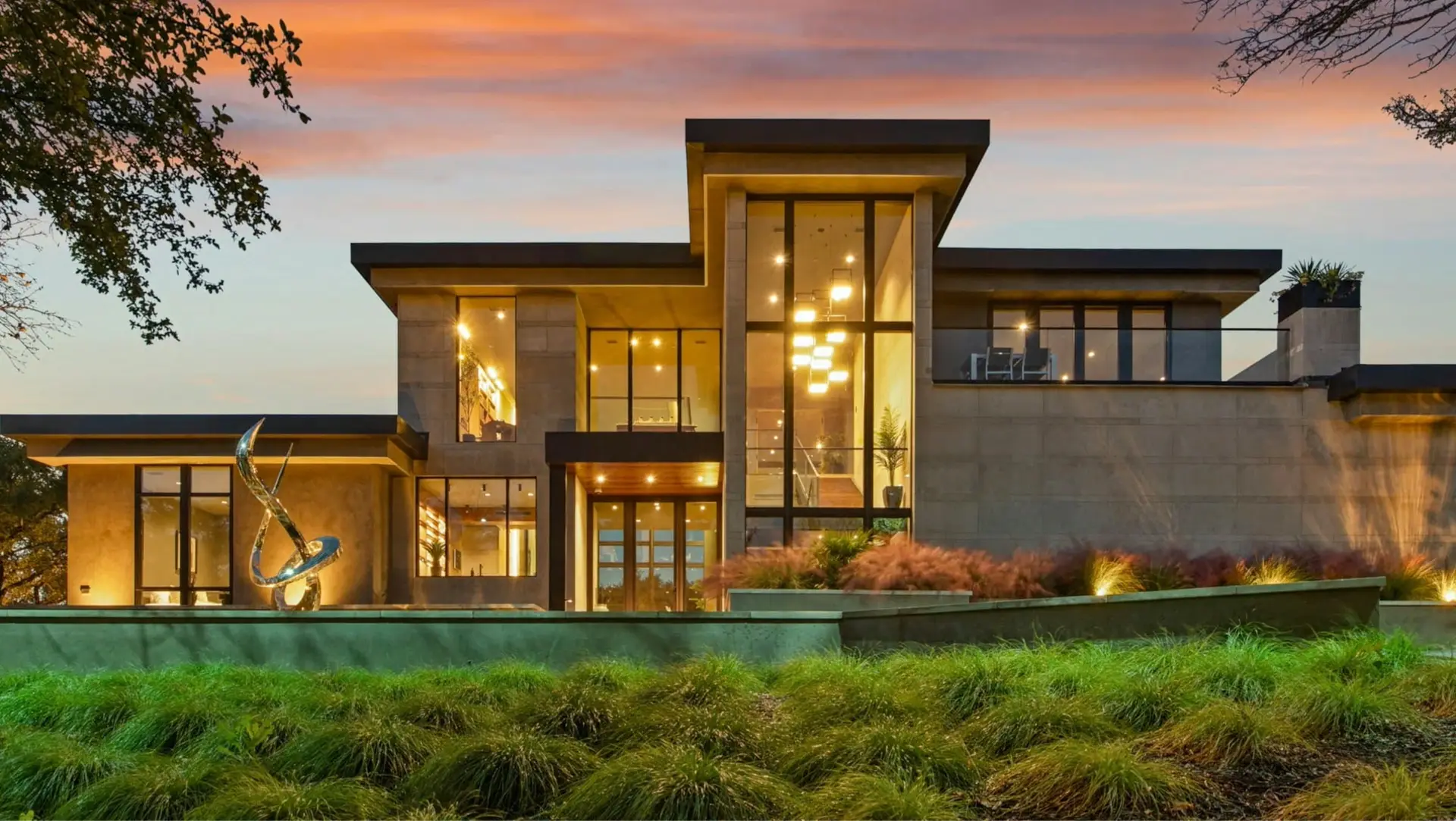 Modern luxury home with a multi-level architectural roofline at dusk