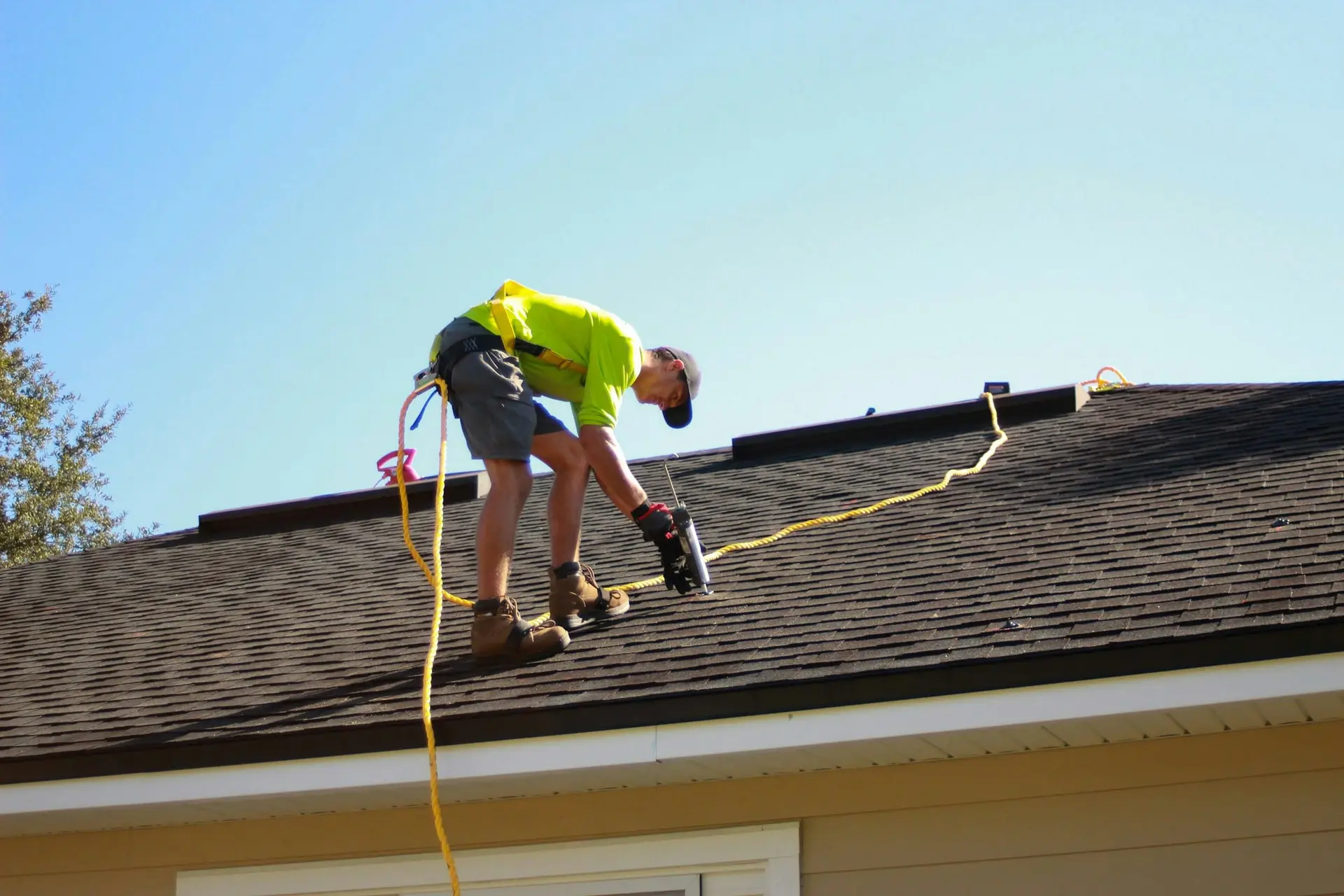 Roofer fastening shingles during a residential roof repair